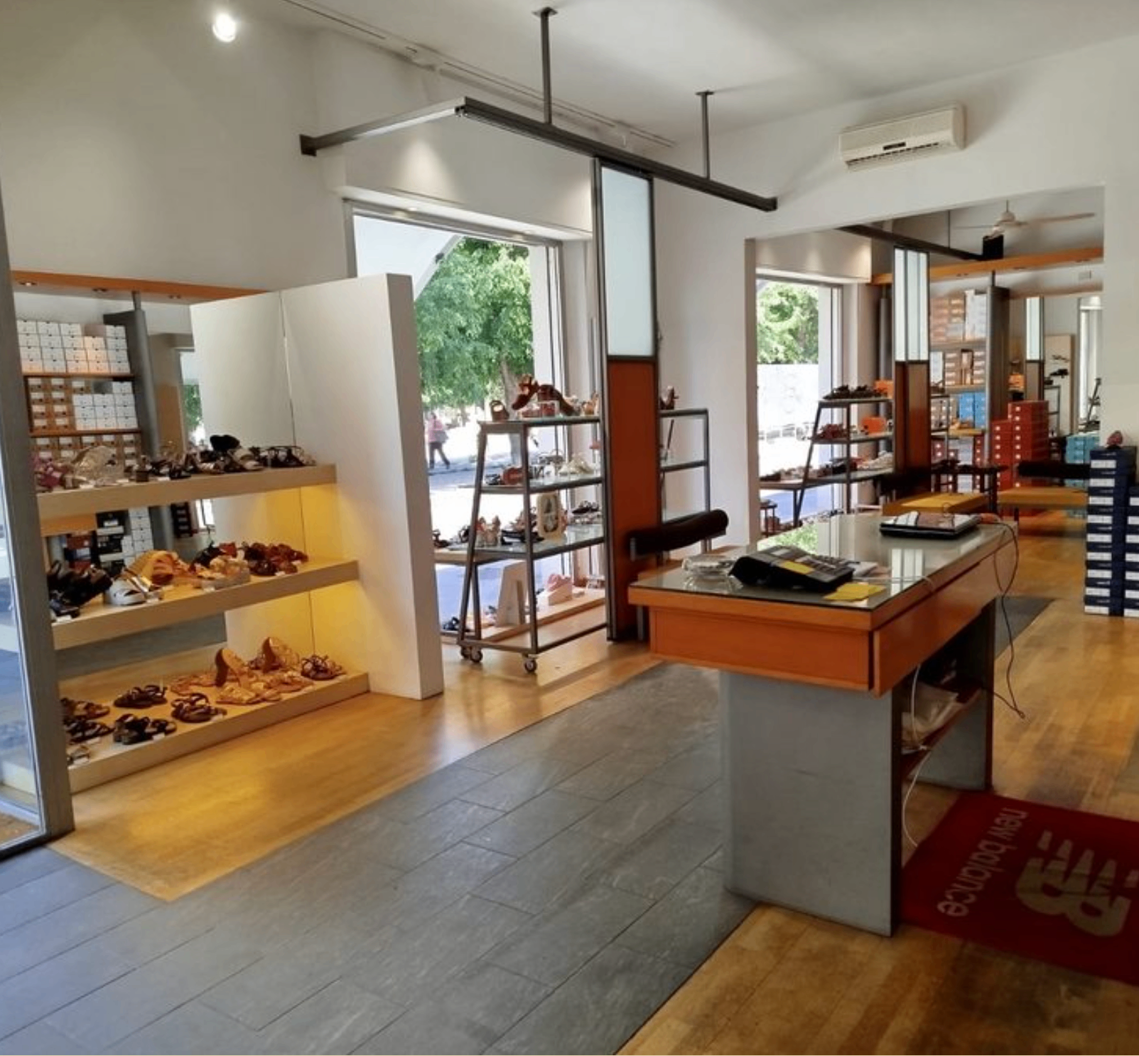 Interno della boutique Daniel Calzature: pavimento in legno, banco cassa e ingresso